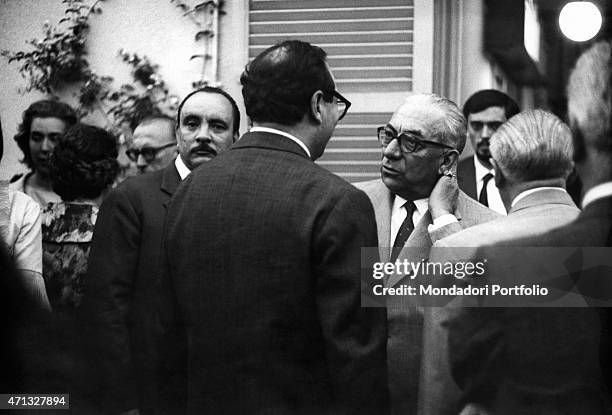 Italian publisher Arnoldo Mondadori chatting with the jurymen of the Strega Prize beside Italian poet Elio Filippo Accrocca. Rome, 1962