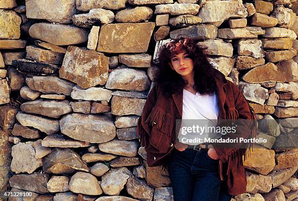 The British singer Kate Bush, leaning against a wall, posing for a photo shoot. Great Britain, 1980