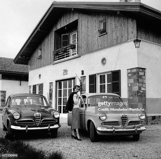 Italian actress Anna Maria Ferrero posing beside two Alfa Romeo Giulietta cars. Milan, April 1955