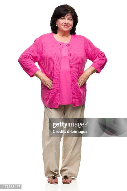 isolated middle aged woman in a pink shirt and tan pants - 50 59 years stock pictures, royalty-free photos & images