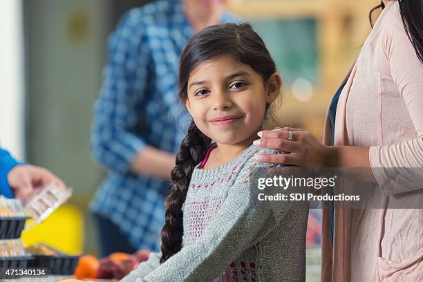 pretty hispanic little girl in line at food bank kitchen - homeless family stock pictures, royalty-free photos & images