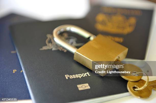 passports with a lock and key on top - travel insurance stock pictures, royalty-free photos & images