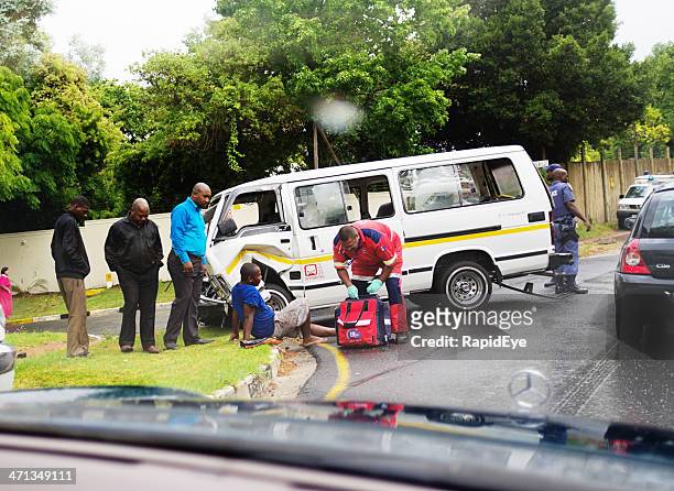 paramedic attending injured passenger after minibus taxi accident - incidental people stock pictures, royalty-free photos & images