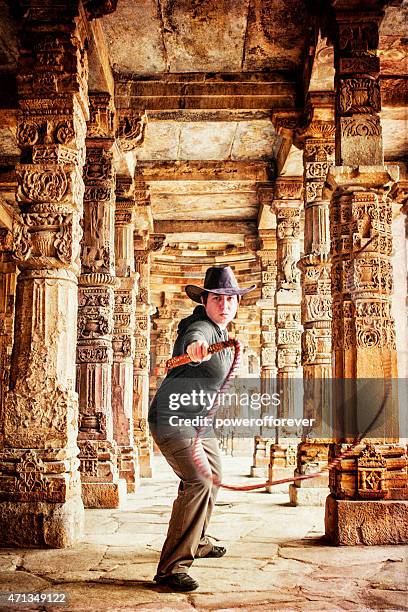 adventurer cracking whip in ancient ruins - female whipping 個照片及圖片檔