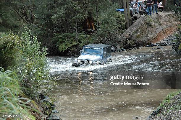 silver jeep tj wrangler mid stream in creek crossing - jeep wrangler stock-fotos und bilder