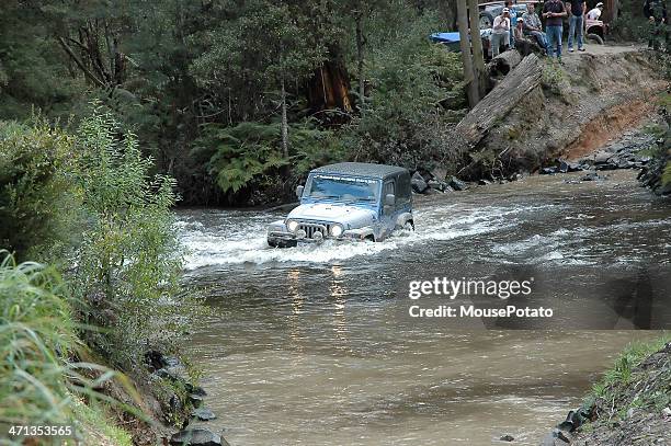 silver jeep tj wrangler mid stream in creek crossing - jeep wrangler stock pictures, royalty-free photos & images