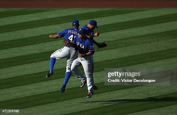 Carlos Peguero, Shin-Soo Choo and Leonys Martin of the Texas Rangers celebrate after their 5-4 win against the Los Angeles Angels of Anaheim in 11...