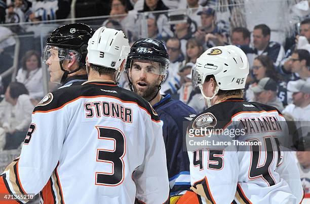 Andrew Ladd of the Winnipeg Jets exchanges words with Clayton Stoner and Sami Vatanen of the Anaheim Ducks during first period action in Game Four of...