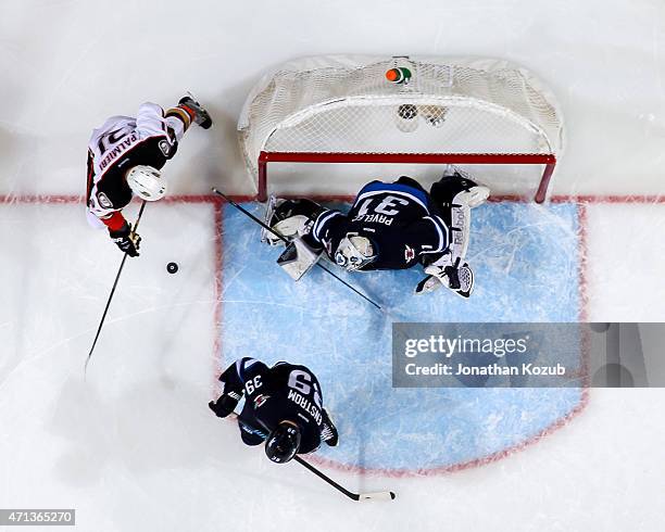 Goaltender Ondrej Pavelec of the Winnipeg Jets guards the net as Kyle Palmieri of the Anaheim Ducks eyes the loose puck during second period action...