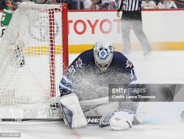 Goaltender Ondrej Pavelec of the Winnipeg Jets covers the puck in the crease during third period action against the Anaheim Ducks in Game Four of the...