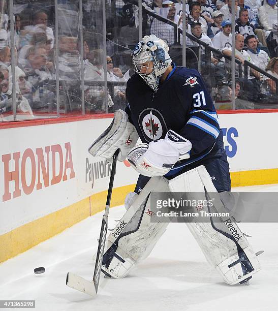 Goaltender Ondrej Pavelec of the Winnipeg Jets plays the puck along the boards during third period action against the Anaheim Ducks in Game Four of...