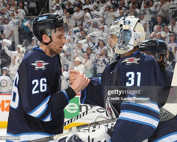 Blake Wheeler of the Winnipeg Jets consoles teammate Ondrej Pavelec following a 5-2 loss to the Anaheim Ducks in Game Four of the Western Conference...