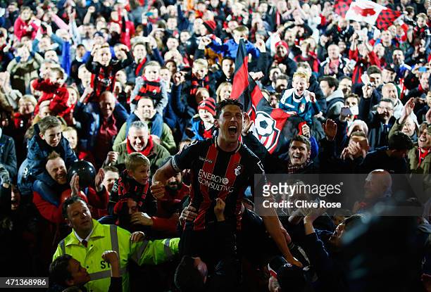 Captain Tommy Elphick of Bournemouth celebrates victory as fans invade the pitch after the Sky Bet Championship match between AFC Bournemouth and...