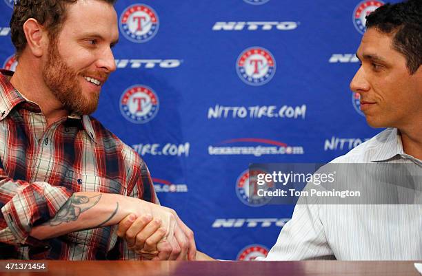 Josh Hamilton, outfielder for the Texas Rangers, shakes hands with Jon Daniels, Texas Rangers President of Baseball Operations and General Manager,...