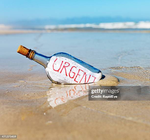 urgent sagt nachricht in einer flasche im water's edge " - schiffbrüchiger stock-fotos und bilder