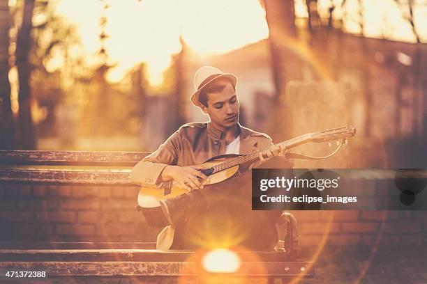 joven tocando la guitarra - puntear un instrumento fotografías e imágenes de stock