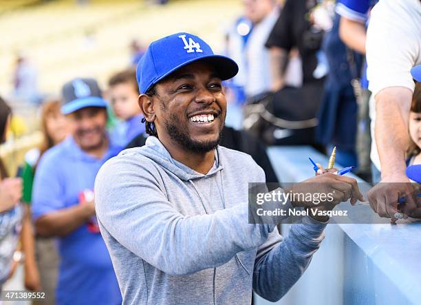 Kendrick Lamar signs autographs before a baseball game between the San Francisco Giants and the Los Angeles Dodgers at Dodger Stadium on April 27,...