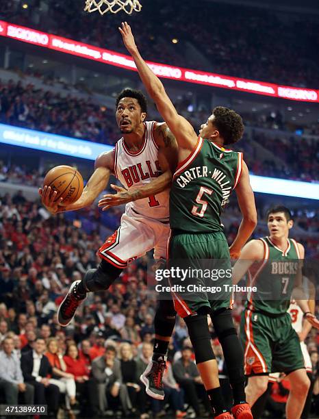 Chicago Bulls guard Derrick Rose scores around Milwaukee Bucks guard Michael Carter-Williams during the first half on Monday, April 27 at the United...