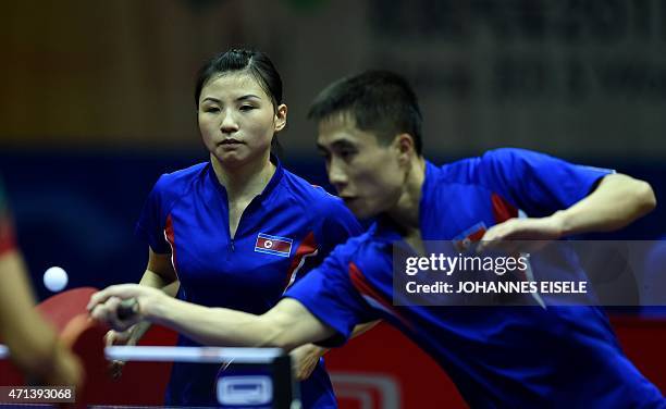 Kim Hyok Bong and Kim Jong of South Korea serve a ball during their mixed doubles match against Diogo Chen and Leila Oliveira of Portugal in the 2015...