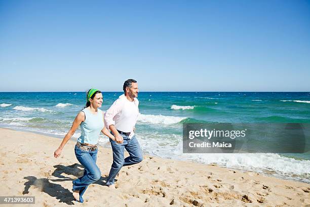 mature couple happy in the beach - couple holding hands stock pictures, royalty-free photos & images