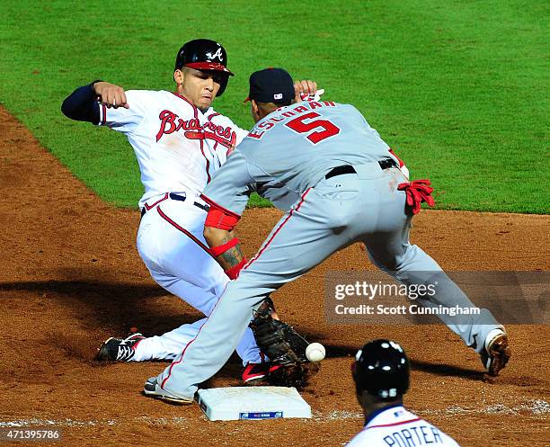 Andrelton Simmons of the Atlanta Braves slides in safely to third base during the fifth inning against Yunel Escobar of the Washington Nationals at...