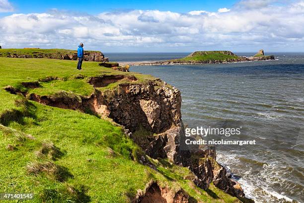 man enjoying view of worm's head, gower peninsula, south wales - rhossili bay stock pictures, royalty-free photos & images