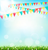 Celebration background with buntings grass and sunlight on sky