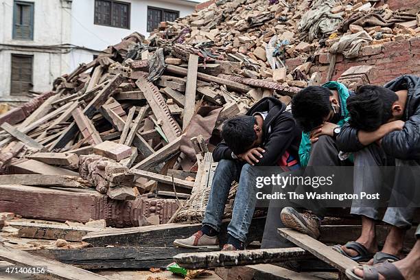 Boys resting in daylight the day after the earthquake, on rubble of what was the Maju Dega temple in Kathmandu, Nepal, April 26, 2015.