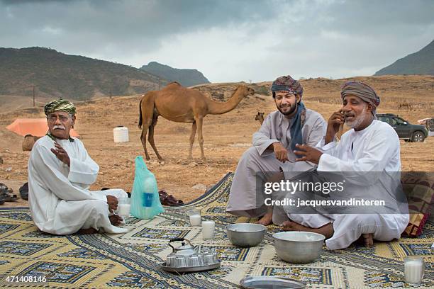 having a chat in the desert near salalah, oman - salalah oman stock pictures, royalty-free photos & images