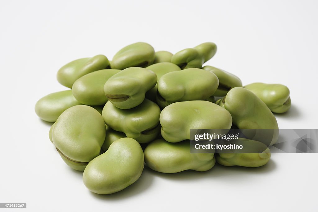 Isolated shot of stacked uncooked broad beans on white background