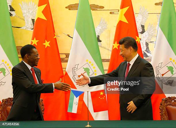 APRIl 28: Equatorial Guinea's President Teodoro Obiang Nguema Mbasogo shakes hands with Chinese President Xi Jinping during a signing ceremony at the...