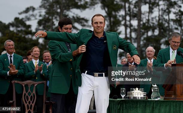 Jordan Spieth of the United States is presented with his Green Jacket by Bubba Watson of the United States after the final round of the 2015 Masters...