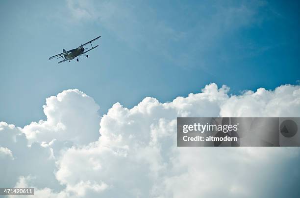 small plane flying above the clouds in the blue sky - propellervliegtuig stockfoto's en -beelden