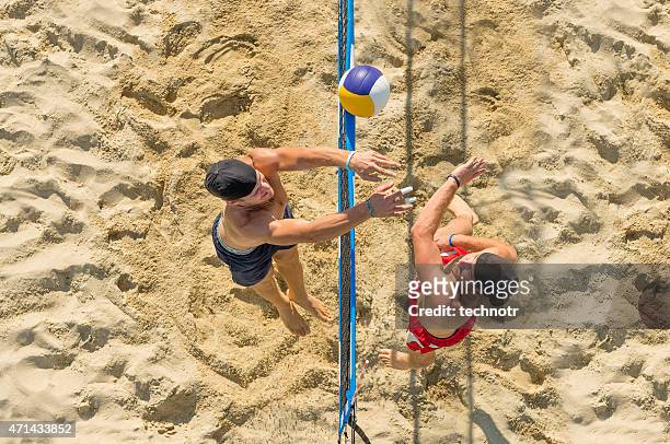upper view of attractive beach volley action on the net - beach volleyball group stock pictures, royalty-free photos & images