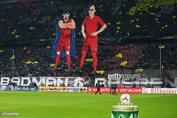 E fans of Bayern Muenchen make character figures of Franck Ribery and Arjen Robben as batman and robin prior to the start of the DFB Cup semi final...