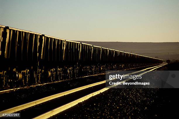 sun glinting on iron ore train - iron mining stock pictures, royalty-free photos & images