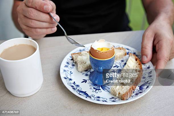 mann essen gekochtes ei für frühstück - gekochtes ei stock-fotos und bilder