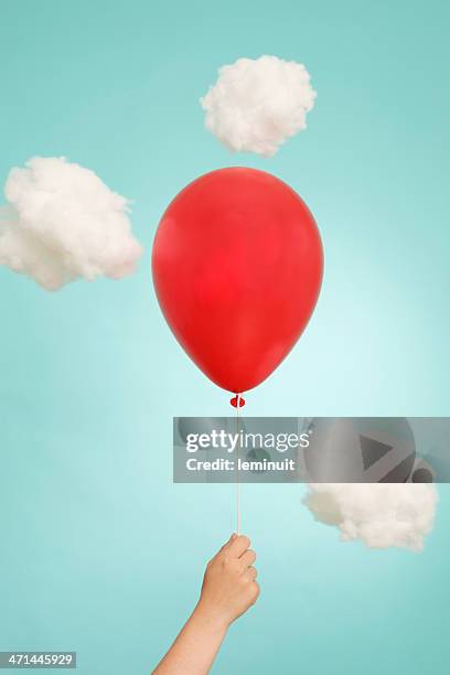 hand, helium red balloon and clouds - heliumballon stockfoto's en -beelden