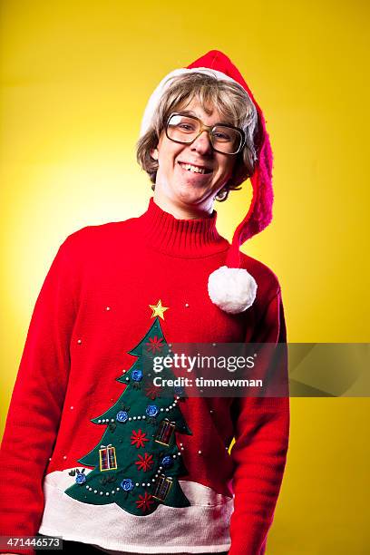 christmas nerd teenage boy with ugly sweater and santa hat - ugly santa stockfoto's en -beelden