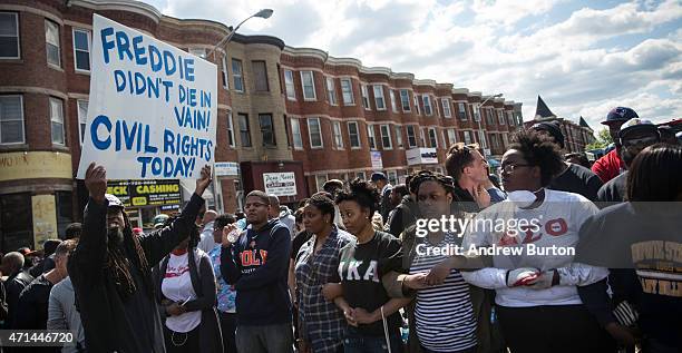 People protest near the CVS pharmacy that was set on fire yesterday during rioting after the funeral of Freddie Gray, on April 28, 2015 in Baltimore,...