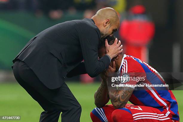 Josep Guardiola, head coach of Muenchen reacts with his player Jerome Boateng after the DFB Cup Semi Final match between FC Bayern Muenchen and...