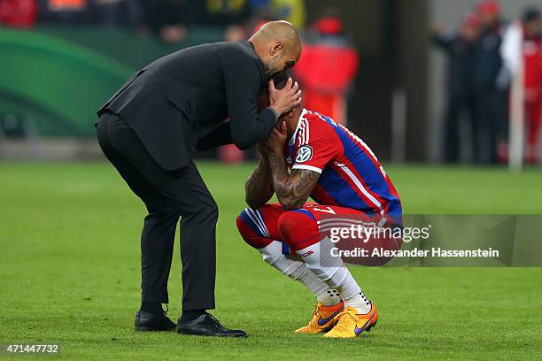 Josep Guardiola, head coach of Muenchen reacts with his player Jerome Boateng after the DFB Cup Semi Final match between FC Bayern Muenchen and...