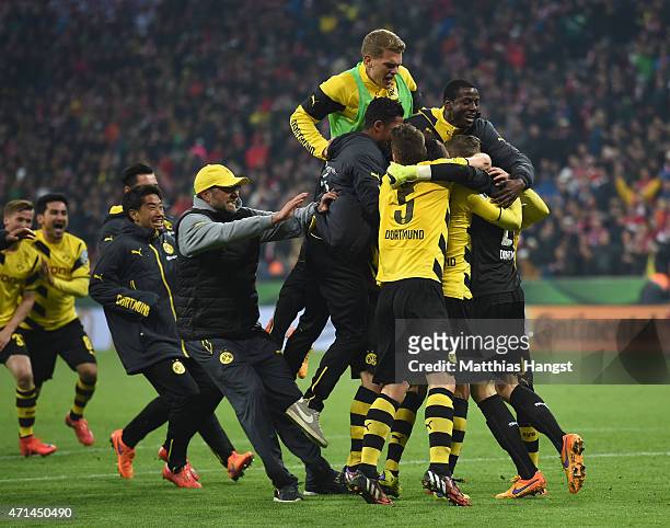The players and head coach Juergen Klopp celebrate after winning during the penalty shoot out during the DFB Cup semi final match between FC Bayern...
