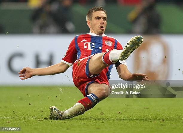 Philipp Lahm of Bayern Muenchen slips as he kicks a penalty during the penalty shoot-out of the DFB Cup semi final match between FC Bayern Muenchen...