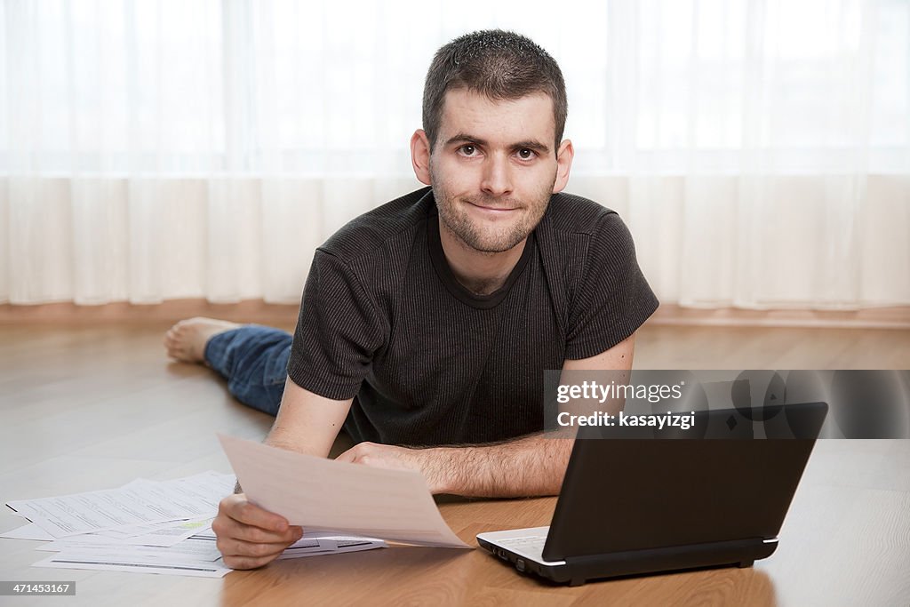 Young man on computer doing paper work