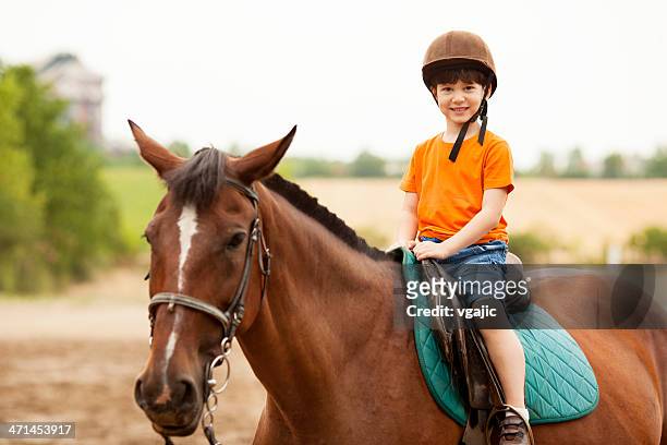 niño montar a caballo al aire libre. - horseriding fotografías e imágenes de stock
