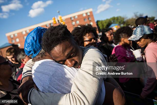 Man hugs a friend after being prayed over during a protest near the CVS pharmacy that was set on fire yesterday during rioting after the funeral of...