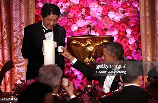 President Barack Obama and Japanese Prime Minister Shinzo Abe participate in a toast with sake during a state dinner at the East Room of the White...