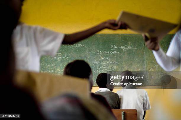 south african teacher hands out books in her classroom - africa school stock pictures, royalty-free photos & images