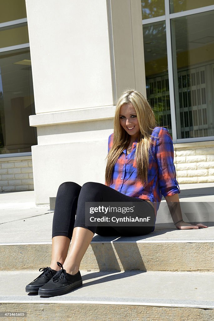 Female teenager sitting on concrete steps